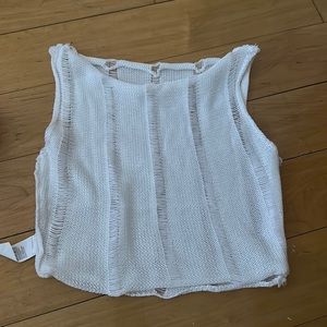 Very cropped white distressed see through tank top. Runs very small.